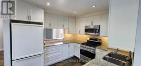 Ajax (Central) apartment for rent - A kitchen with white cabinets and a granite countertop.