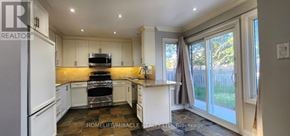 Ajax (Central) apartment for rent - A well-lit kitchen with white appliances and a wooden floor.