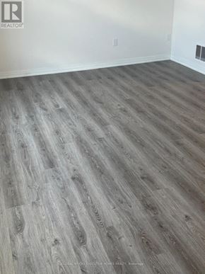 Clarington (Bowmanville) townhouse for rent - A room with a wooden floor and white walls.