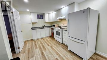 Brampton (Northwood Park) apartment for rent - A kitchen with a white fridge, white cabinets, and a wooden floor.