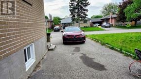 Brampton (Northwood Park) apartment for rent - A red car is parked on a driveway in front of a house.