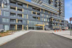Burlington (Alton) condo for rent - A modern building with a glass facade and a car parked in front.