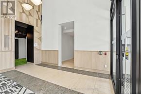 Burlington (Alton) condo for rent - A hallway with a black and white rug on the floor and a glass door on the right.