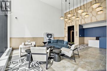 Burlington (Alton) condo for rent - A modern living room with a white sofa and a black and white rug.