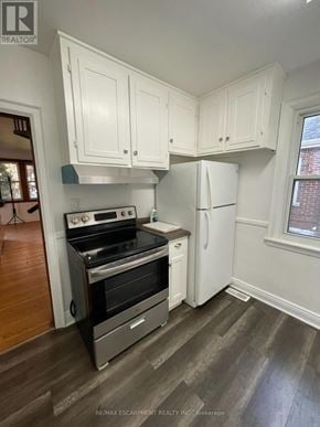 Hamilton (Ainslie Wood) apartment for rent - A kitchen with white cabinets and a black stove top oven.