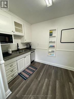 Hamilton (Ainslie Wood) apartment for rent - A kitchen with white cabinets and a striped rug on the floor.