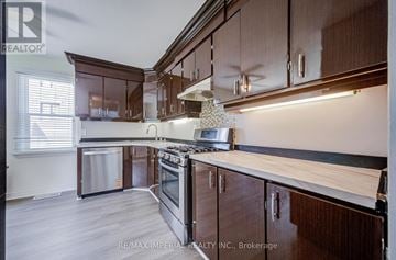Richmond Hill (Oak Ridges Lake Wilcox) apartment for rent - A kitchen with wooden cabinets and a stove top oven.