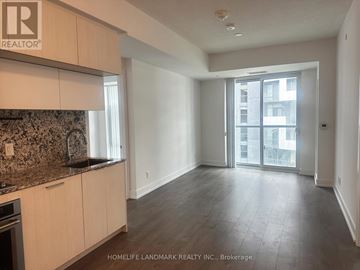 Toronto (Bayview Village) condo for rent - A spacious kitchen with wooden cabinets and a granite countertop.