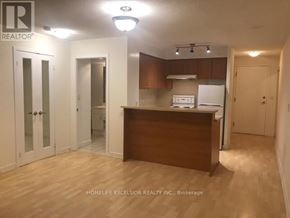 Toronto (Woburn) condo for rent - A realtor photo of a kitchen area with white appliances and wooden cabinets.