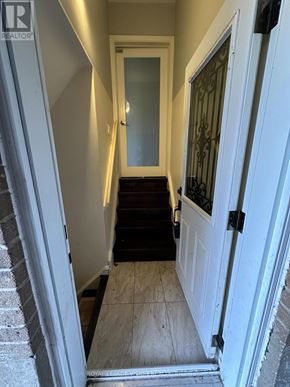 Toronto (Woburn) apartment for rent - A hallway with a door on the right and a staircase on the left.