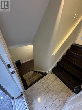 Toronto (Woburn) apartment for rent - A staircase with a wooden handrail and a tiled floor.