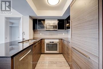 Toronto (Willowdale West) condo for rent - A modern kitchen with wooden cabinets and a central island.