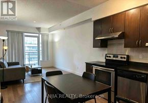 Richmond Hill (Doncrest) condo for rent - A modern kitchen with stainless steel appliances and a dining table.