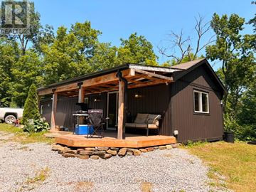 Trent Lakes apartment for rent - A small cabin with a deck and a covered entrance.