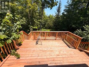 Trent Lakes apartment for rent - A wooden deck with a railing and a chair.