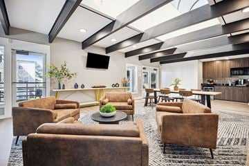Charlotte apartment for rent - A modern living room with brown couches and a flat screen TV mounted on the wall.