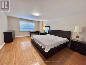 Toronto (L'amoreaux) apartment for rent - A bedroom with a bed, nightstand, and a window with blinds.