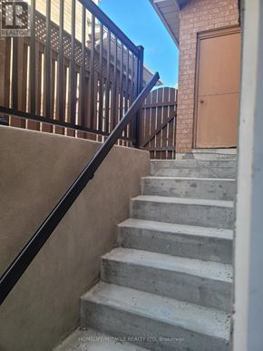 Markham (Rouge Fairways) apartment for rent - A set of stairs with a black railing leading to a brown door.