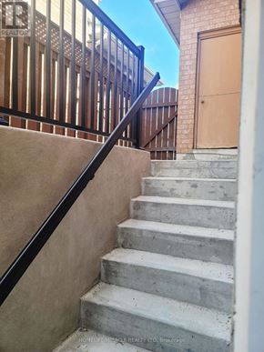 Markham (Rouge Fairways) apartment for rent - A set of stairs with a black railing leading to a brown door.
