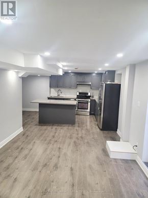 Markham (Rouge Fairways) apartment for rent - A kitchen with a black refrigerator and a white countertop.