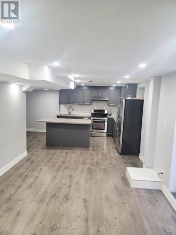 Markham (Rouge Fairways) apartment for rent - A kitchen with a black refrigerator and a white countertop.