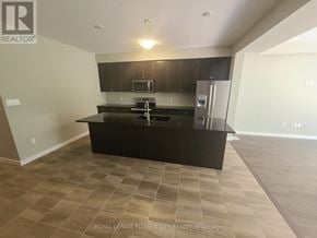 Kitchener townhouse for rent - A kitchen with a black countertop and a refrigerator.