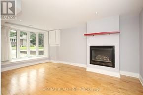 Toronto (Willowdale West) apartment for rent - A room with a fireplace and a window overlooking a lawn.