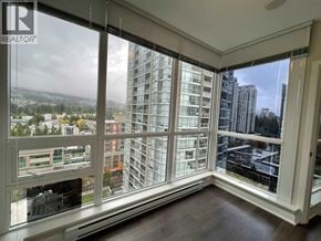 Coquitlam apartment for rent - A view of a cityscape from a window in a room with wooden floors.
