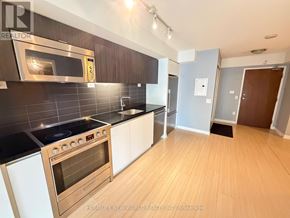 Toronto (Waterfront Communities) condo for rent - A modern kitchen with stainless steel appliances and white cabinets.
