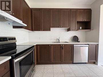 Ottawa townhouse for rent - A kitchen with brown cabinets and a white tile backsplash.
