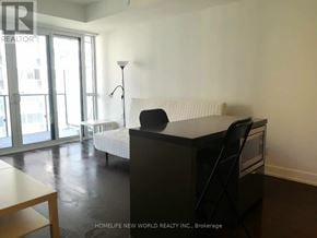 Toronto (Bay Street Corridor) condo for rent - A black desk with a chair in front of a white sofa.