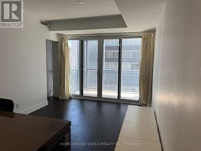Toronto (Bay Street Corridor) condo for rent - A room with a table, a couch, and a window with a view of a building outside.