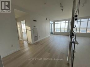 Toronto (Waterfront Communities) condo for rent - A spacious room with wooden flooring and large windows overlooking the water.