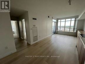 Toronto (Waterfront Communities) condo for rent - A spacious room with wooden flooring and a large window.