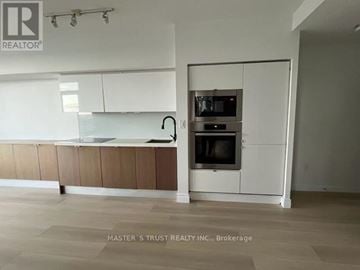 Toronto (Waterfront Communities) condo for rent - A kitchen with a sink, stove, and oven in a white and brown cabinet.