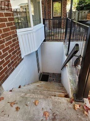 Toronto (Rouge) apartment for rent - A staircase with a black railing and a brick wall.