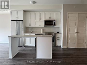 Oakville (Jm Joshua Meadows) condo for rent - A kitchen with white cabinets and a white island.