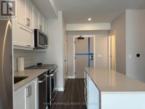 Oakville (Jm Joshua Meadows) condo for rent - A kitchen with white cabinets and a refrigerator.