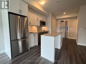 Oakville (Jm Joshua Meadows) condo for rent - A kitchen with a refrigerator, microwave, and cabinets.