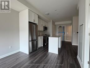 Oakville (Jm Joshua Meadows) condo for rent - A kitchen with a refrigerator, microwave, and cabinets.