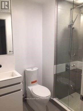 Toronto (Church-Yonge Corridor) condo for rent - A white toilet with a toilet paper holder and a glass shower stall.