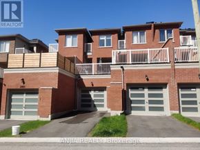 Pickering townhouse for rent - Apartment building with balconies and garage doors.