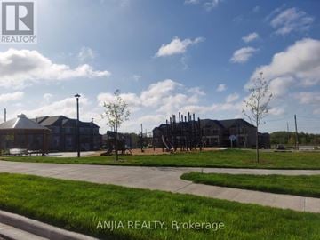 Pickering townhouse for rent - A sunny day at Brokerage with a building and a playground.