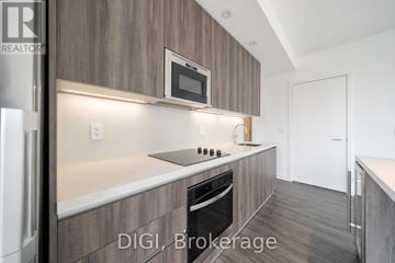 Toronto (Church-Yonge Corridor) condo for rent - A modern kitchen with a refrigerator, microwave, and oven.