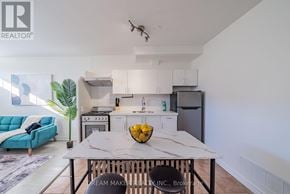 Oshawa (Vanier) townhouse for rent - A modern kitchen with a marble table and a blue sofa.
