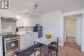 Oshawa (Vanier) townhouse for rent - A kitchen with white cabinets and a black stove top oven.