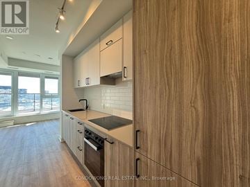 Toronto (Banbury-Don Mills) condo for rent - A kitchen with wooden cabinets and a stove top oven.