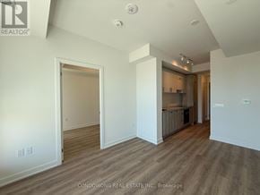 Toronto (Banbury-Don Mills) condo for rent - A spacious room with wood flooring and white walls, with a doorway leading to another room.