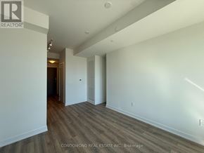 Toronto (Banbury-Don Mills) condo for rent - A room with wood flooring and white walls, with a doorway leading to another room.