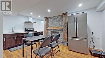 Mississauga (Erin Mills) apartment for rent - A kitchen with a table and chairs in front of a brick wall.